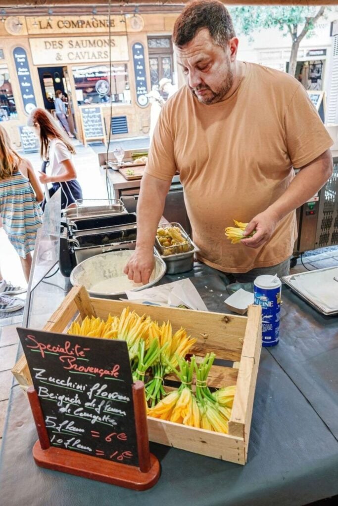 A slice of Cuisine Niçoise traditional tourte de blettes, a Swiss chard and pine nut tart, dusted with powdered sugar and served with a caramel drizzle.