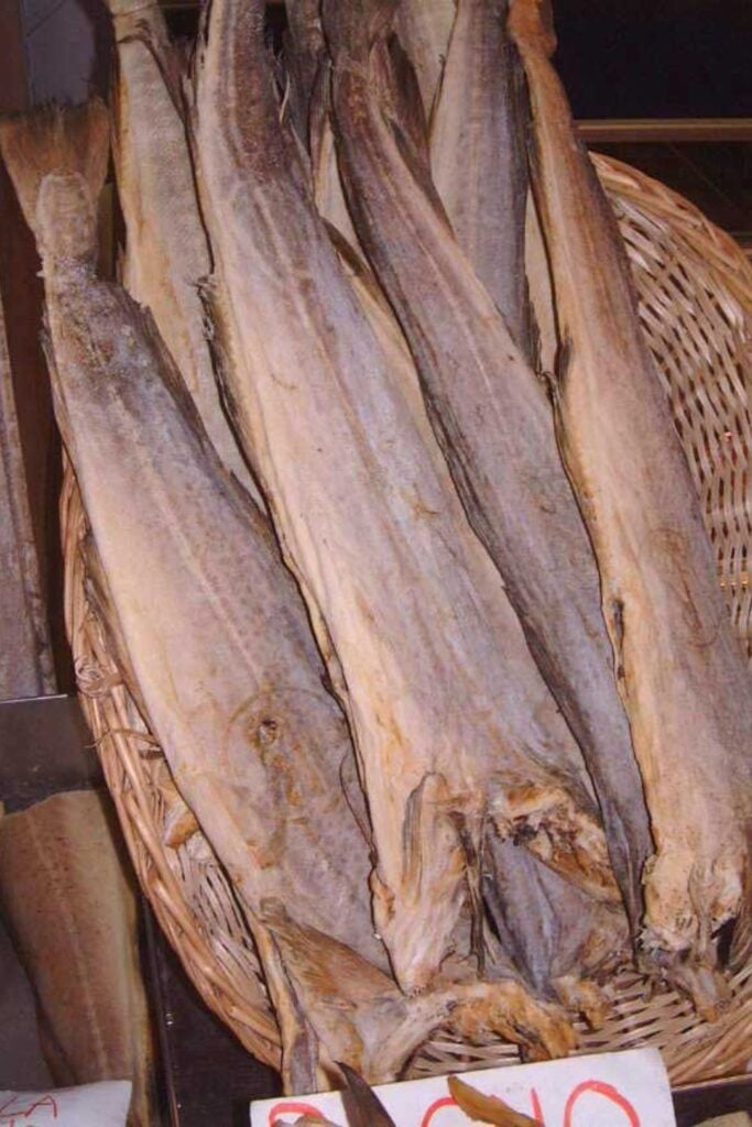 A basket filled with dried fish, an essential ingredient in Cuisine Niçoise, commonly used in traditional Mediterranean dishes.