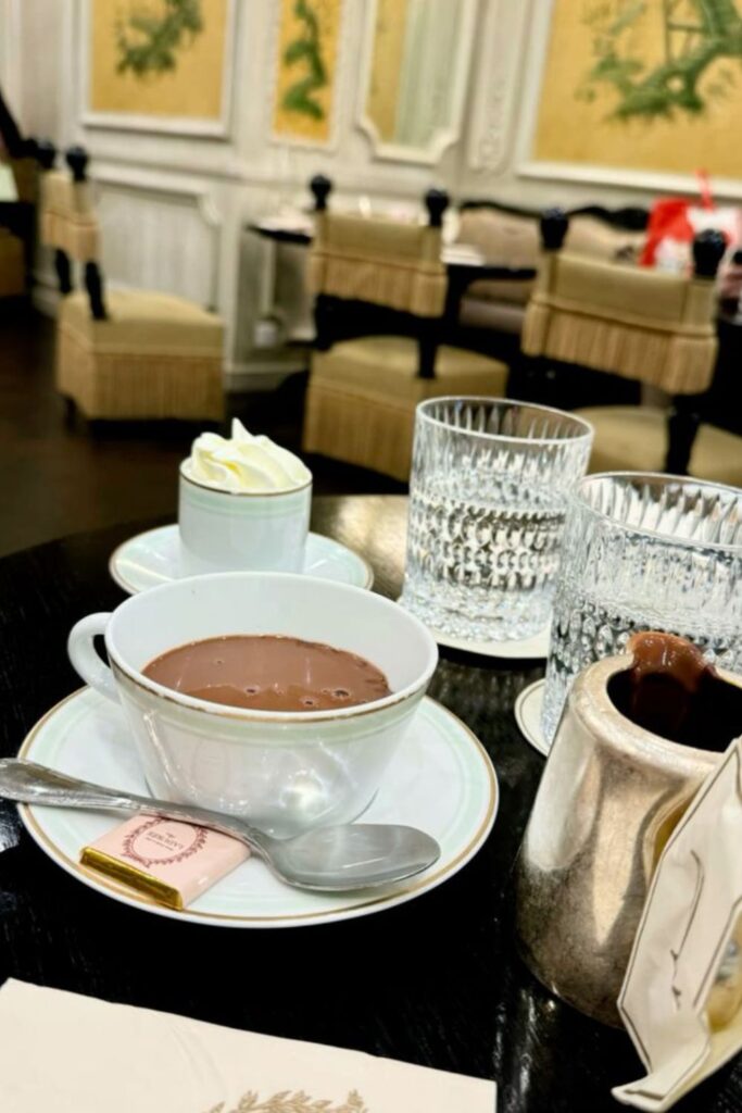 A luxurious cup of the best hot chocolate in Paris, served with whipped cream and an elegant setting at Ladurée.