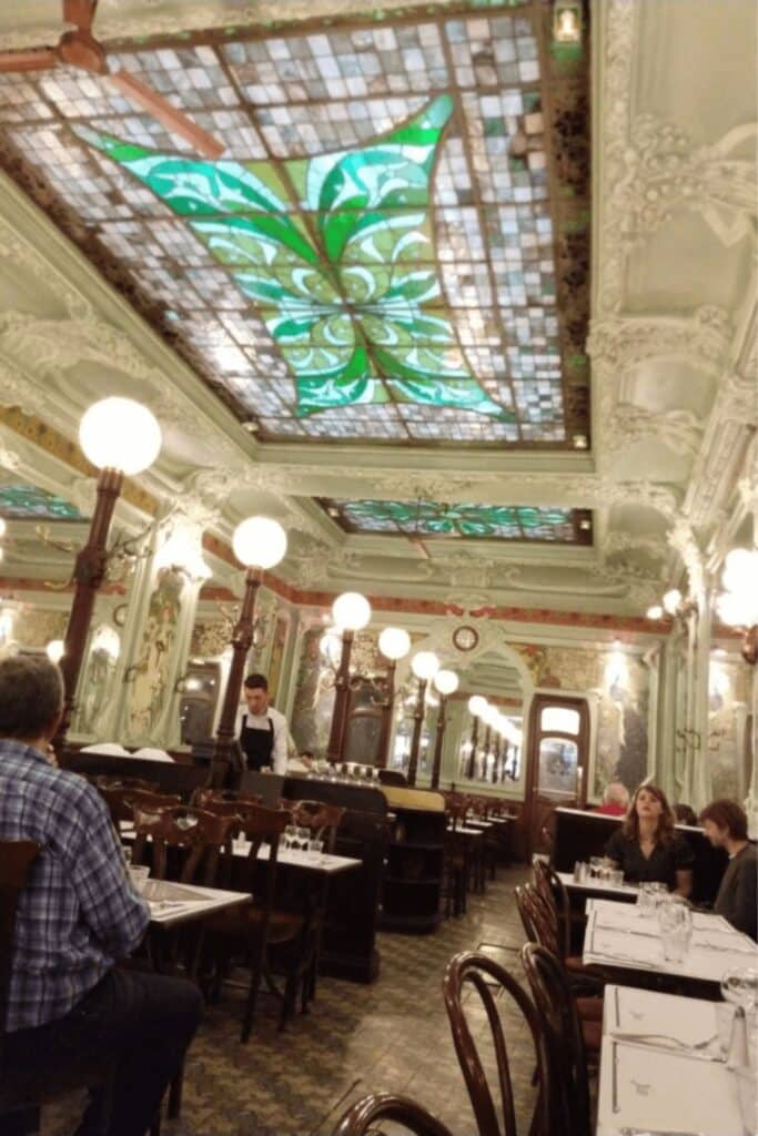 Art Nouveau interior of Bouillon Julien, one of the most visually stunning bouillon restaurants in Paris, with stained glass ceilings and vintage décor.