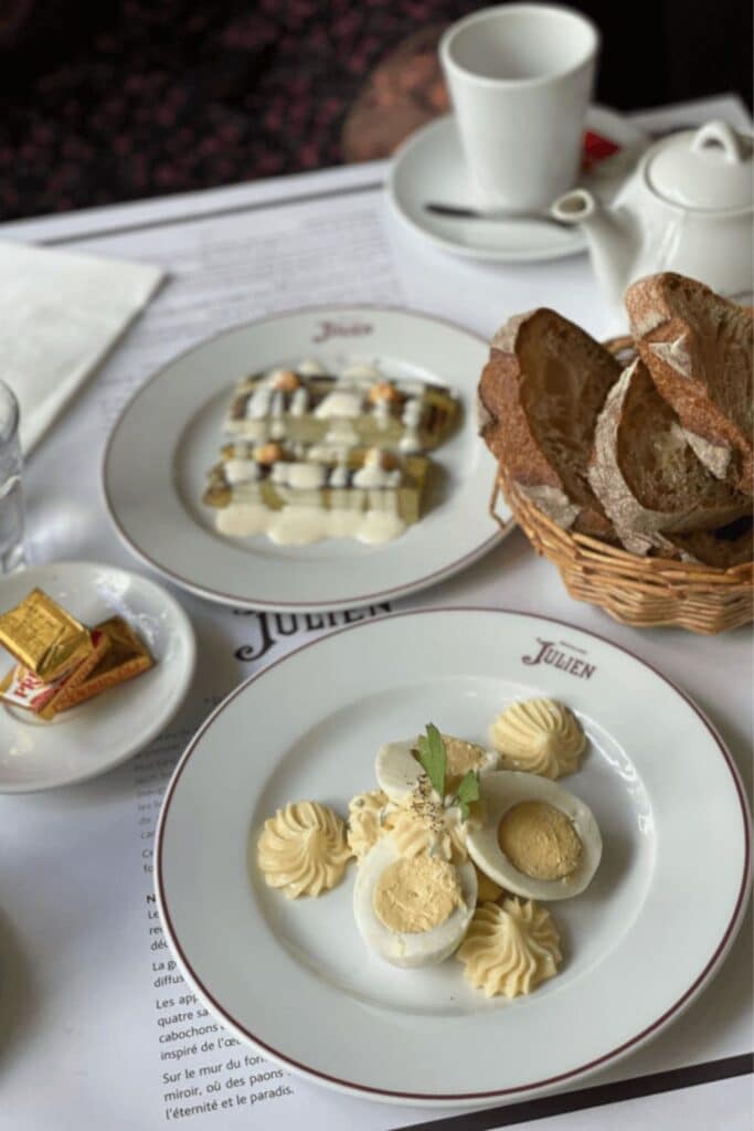 Deviled eggs and leeks with vinaigrette served at Bouillon Julien, one of the most elegant bouillon restaurants in Paris, with fresh bread and coffee on the table.