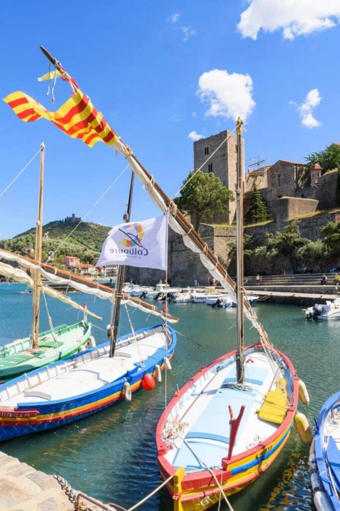 Admiring the vibrant Catalan boats in the charming harbor of Collioure, with its historic fortress in the background, is one of the top things to do in Occitanie France.