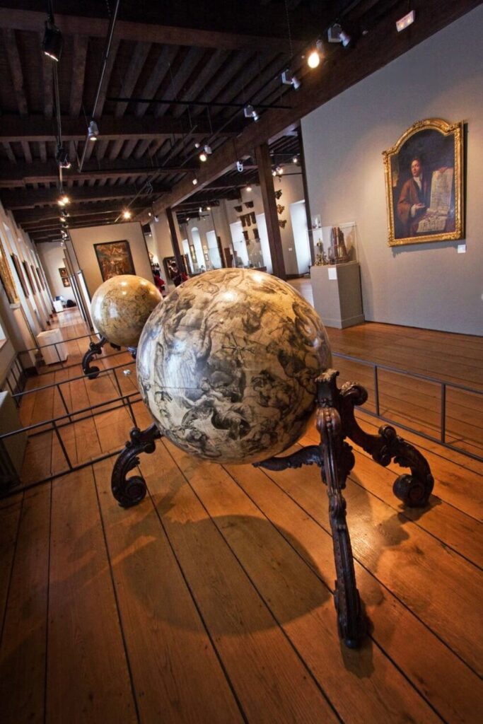 Ornate globes and historical artifacts on display at the Musée de l'Hospice Comtesse, a cultural gem among the top things to do in Lille.