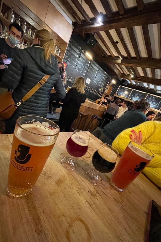 A cozy craft beer bar in Lille, where visitors enjoy a variety of colorful brews, offering a vibrant experience among the top things to do in Lille.