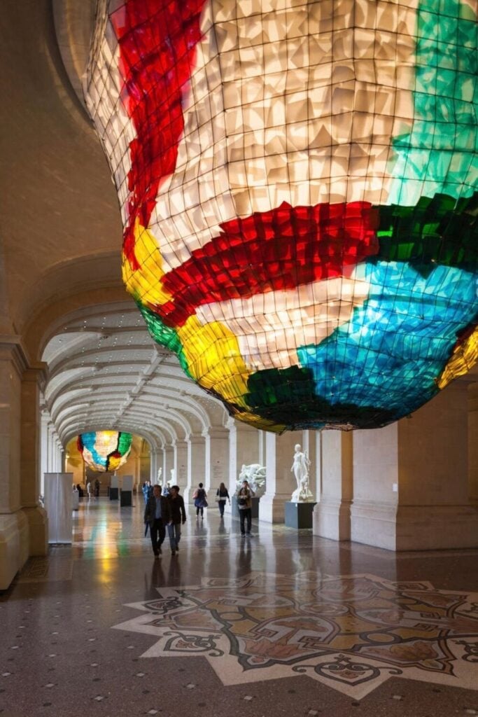 A colorful art installation hangs in the ornate hallway of the Palais des Beaux-Arts, a highlight among the top things to do in Lille.