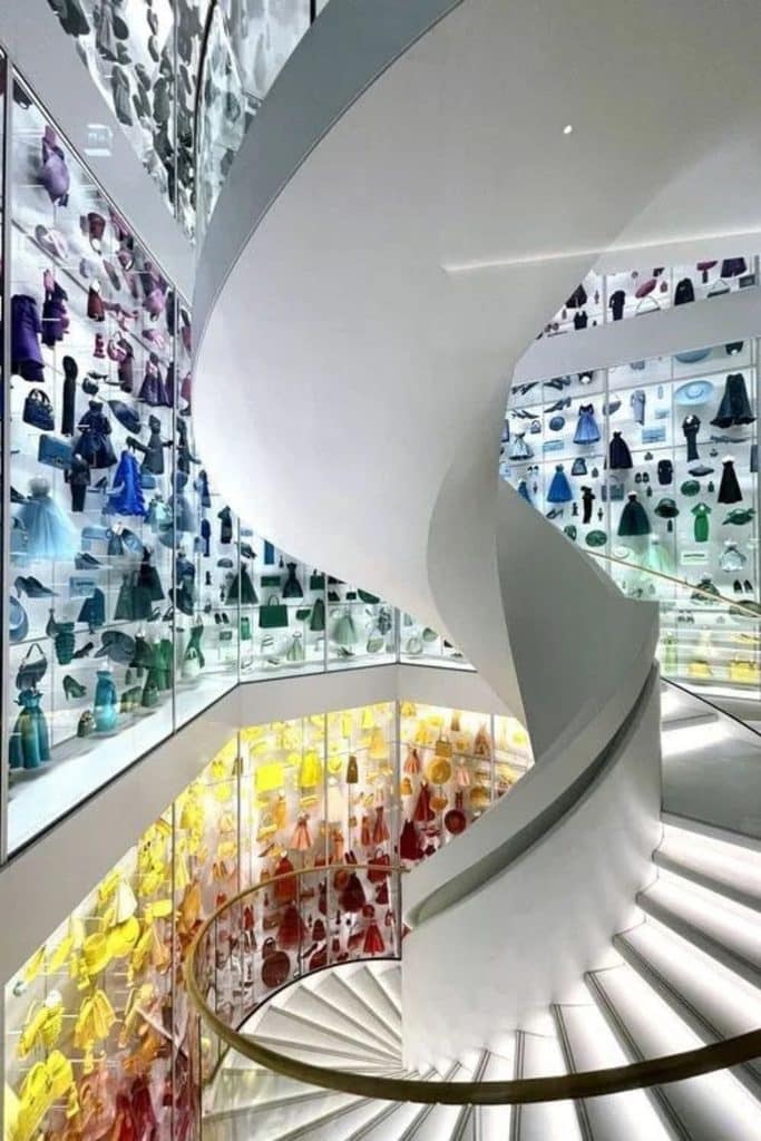 Spiral staircase lined with colorful miniature dresses and accessories at La Galerie Dior in Paris.