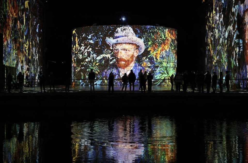 Visitors admire immersive digital projections of Van Gogh’s artwork at Les Bassins des Lumières, a unique art experience and one of the most captivating things to do in Bordeaux.