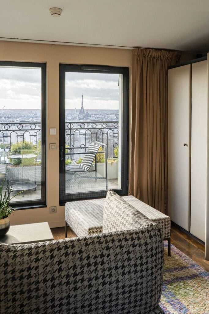 A cozy hotel suite with a private terrace offering a panoramic view of the Eiffel Tower, exemplifying Paris hotels with Eiffel Tower views.