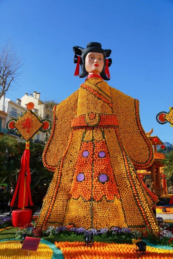 A stunning citrus sculpture of a traditional figure, made from oranges and lemons, stands tall at the Menton Lemon Festival—one of the most unique and vibrant things to do in Menton France.