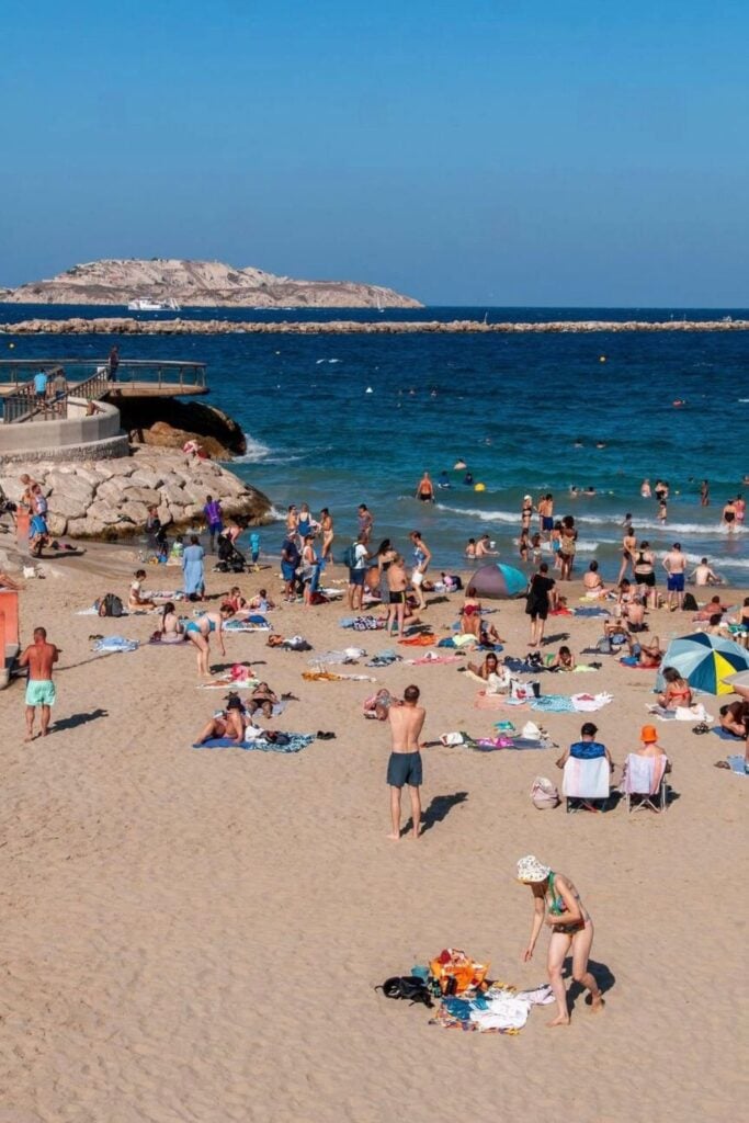 Sunbathers and swimmers enjoy the sandy shores of Plage des Catalans, a popular beach near the city center, making a seaside escape one of the best things to do in Marseille France.