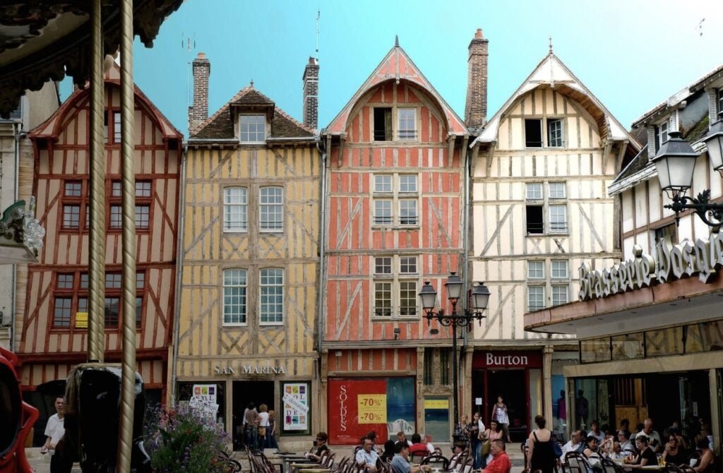 A charming square in Troyes, France, featuring colorful half-timbered houses and lively cafés, making it a picturesque destination for day trips from Paris France.