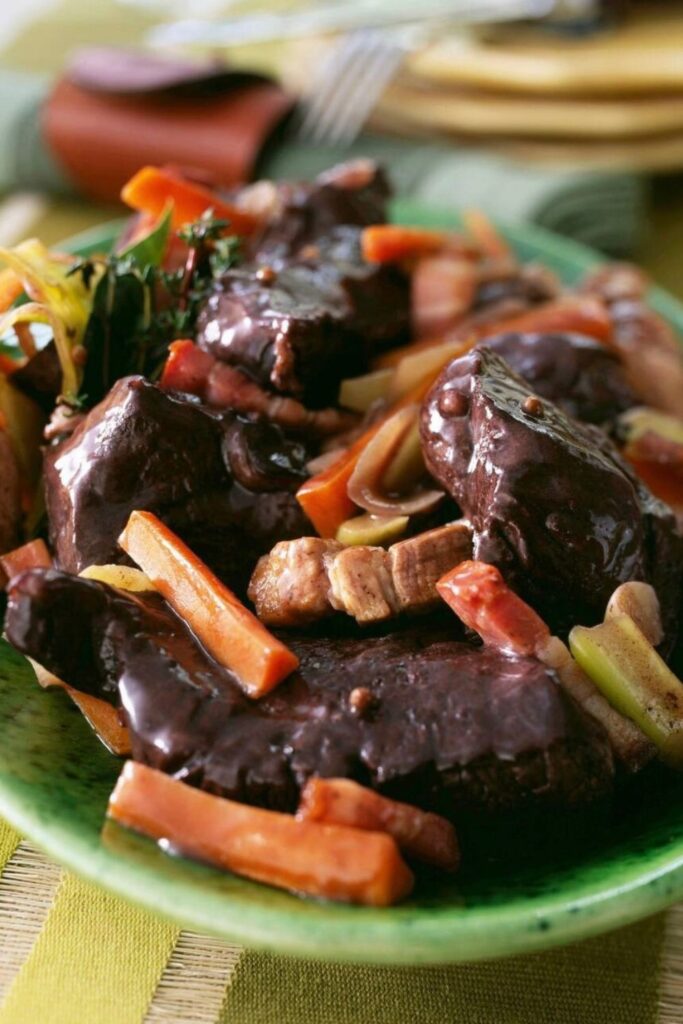 A hearty plate of beef stew in red wine sauce, served with carrots, bacon, and herbs—an essential dish in any Marseille Food Guide.
