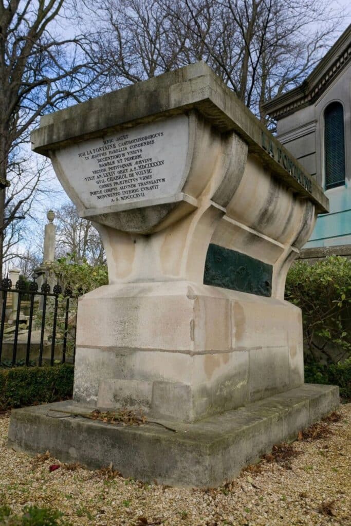 The grand tomb of Jean de La Fontaine at Père Lachaise Cemetery features a sculpted stone sarcophagus with Latin inscriptions, honoring the famed French poet and fabulist.