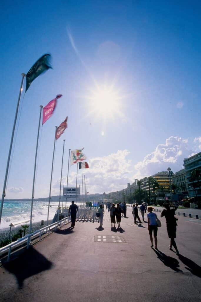 Walking along the Promenade des Anglais under the Mediterranean sun, with flags fluttering in the sea breeze, is one of the most iconic things to do in Nice for a perfect Riviera experience.