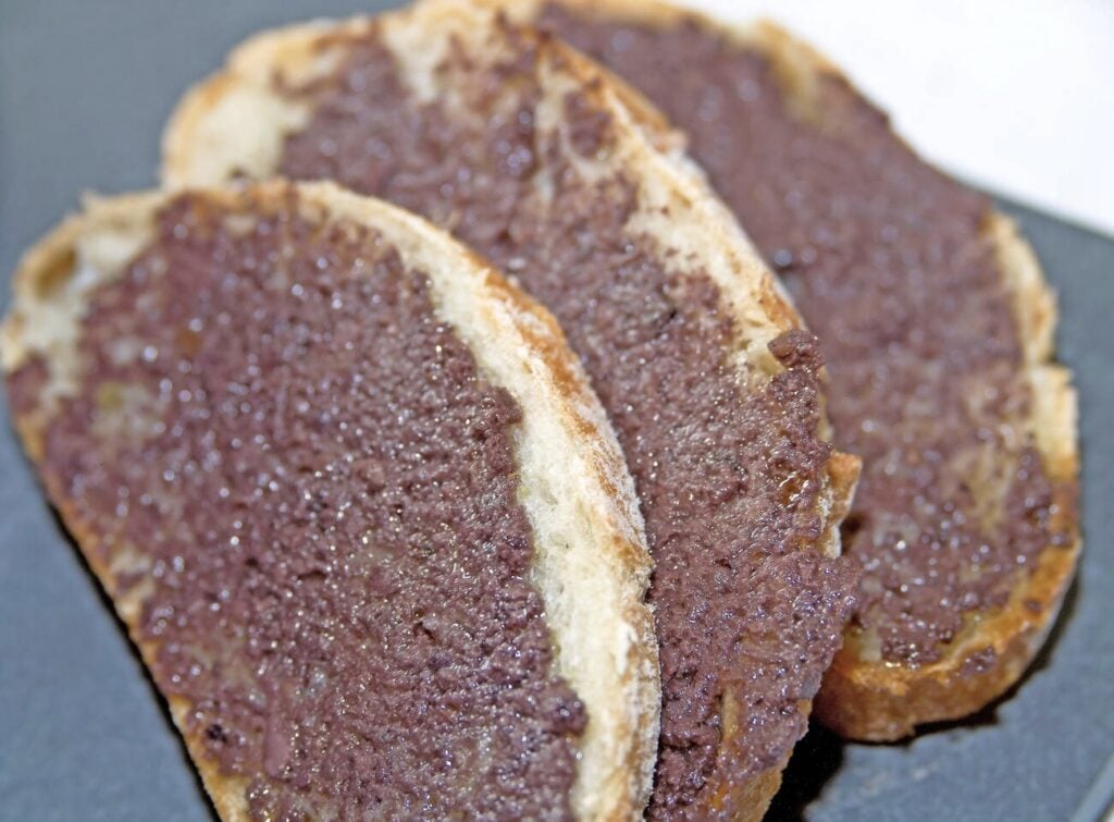 Slices of crusty bread topped with rich, savory tapenade—a quintessential Provençal specialty featured in any Marseille Food Guide.
