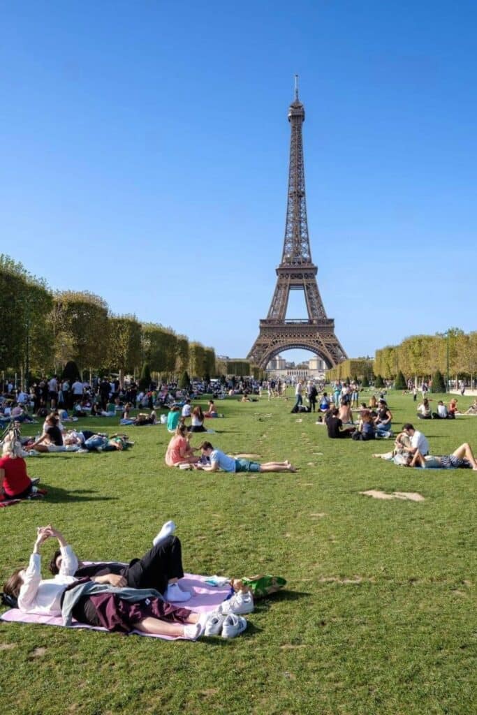 Crowds enjoying a sunny day at Champ de Mars with the Eiffel Tower in the background—an iconic spot near many top hotels if you're wondering where to stay in Paris for classic views and central access.