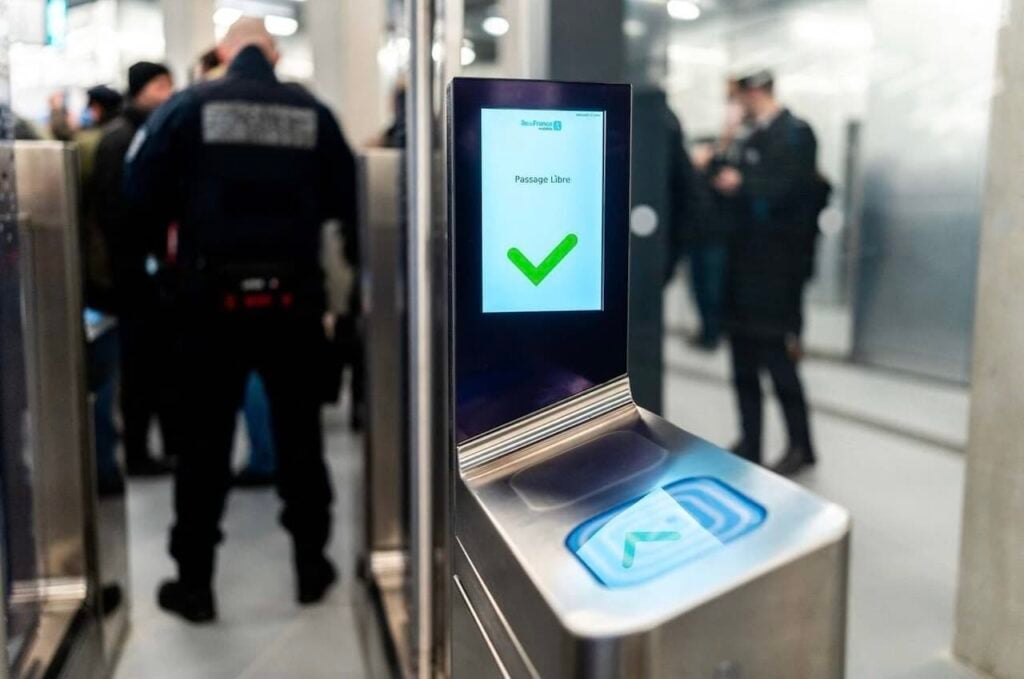 A Navigo pass being validated at a metro turnstile, showing how to use the metro in Paris with the new tap-and-go gates.
