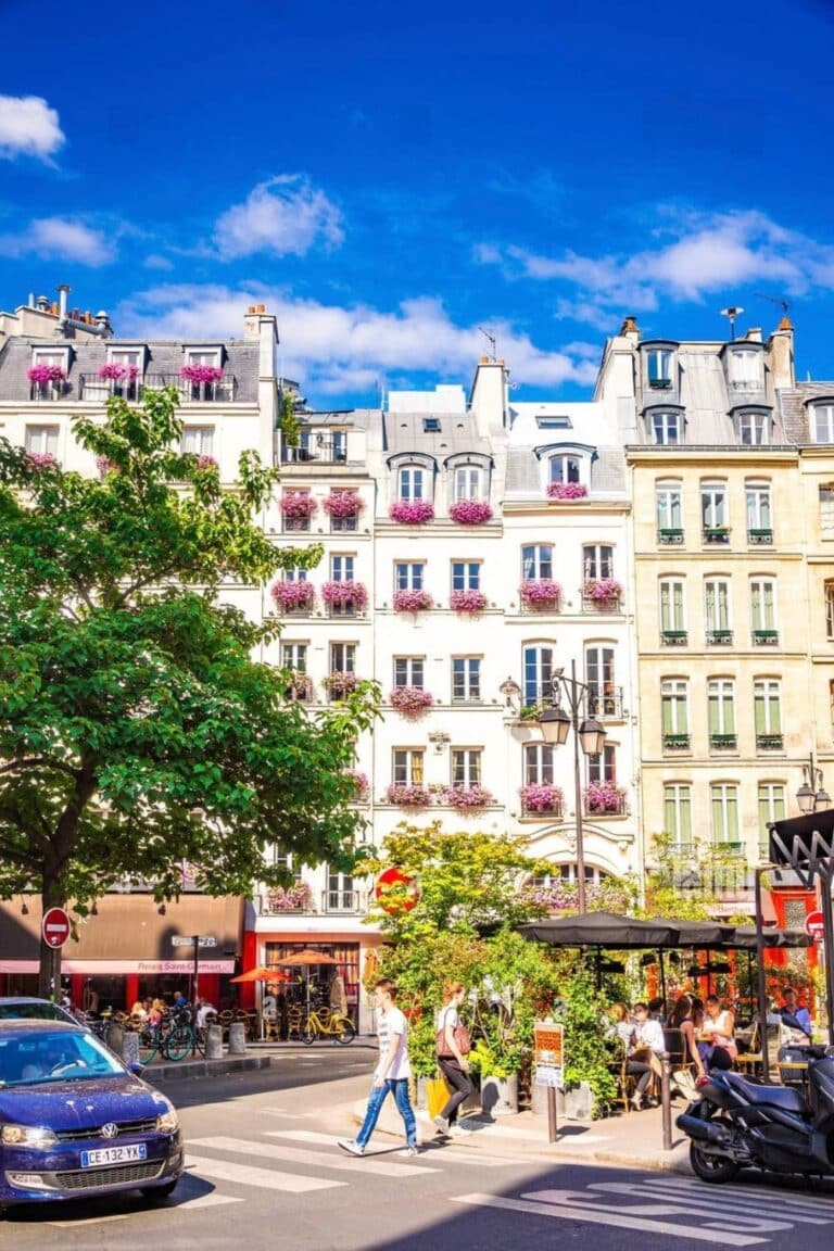 Charming Parisian buildings with flower-filled balconies and lively cafés in Saint-Germain-des-Prés—an elegant and timeless neighborhood to consider when deciding where to stay in Paris for boutique hotels and Left Bank flair.